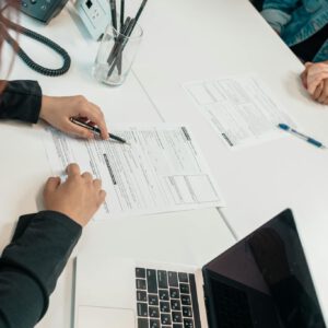 A professional meeting with document signing at an office desk, focusing on teamwork.